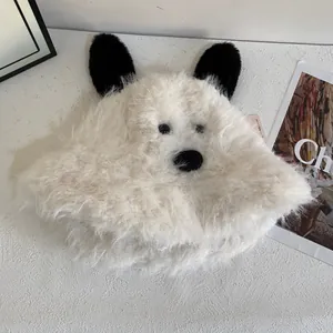 Close-up of soft white plush puppy bucket hat with black 3D ears and furry texture
