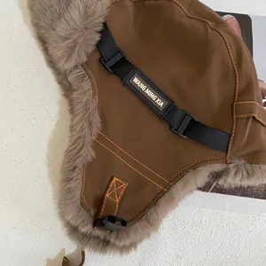 Detalle del gorro de aviador marrón con forro de piel sintética y costuras naranjas