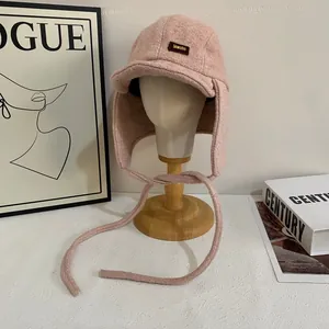 Dettaglio del cappello da aviatore rosa in lana d'agnello con etichetta in pelle su supporto