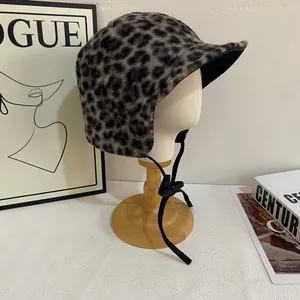 Detail of leopard print trapper hat featuring plush texture and black bow tie closure