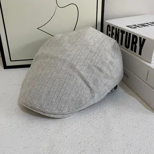 Detail of grey herringbone beret featuring sparkling rhinestones on textured fabric