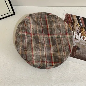 Retro plaid beret in taupe tweed fabric shown on a minimalist prop background