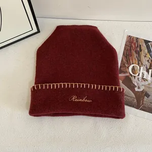 Detalle del gorro de punto granate con bordado Rainbow y dobladillo cosido a mano