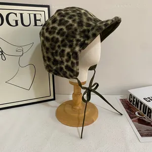 Close-up of olive green leopard print trapper hat with soft faux fur and ear flaps