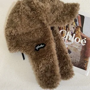 Close-up of thick plush brown trapper hat with soft faux fur texture and side patch
