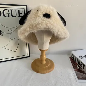 Detail of plush dog-shaped bucket hat featuring long black ears and fuzzy white texture