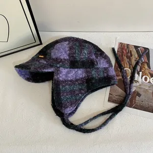Détail de la chapka à carreaux violets et noirs avec doublure épaisse et étiquette en cuir