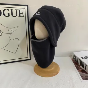 Detalle del gorro de aviador de forro polar negro con protector de cuello y bordado