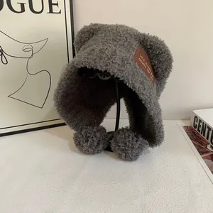 Dettaglio del cappello in pile teddy grigio scuro con orecchie da orso e pompon