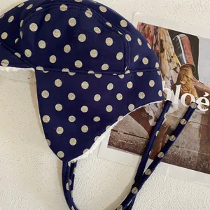 Close-up of navy blue polka dot aviator hat with soft faux shearling lining