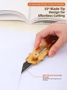 Detail of golden stainless steel utility knife cutting paper with sharp 55 degree SK5 blade