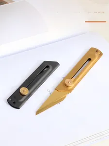 Detail of black and golden stainless steel utility knives with locking metal knobs