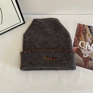 Detalle del gorro de punto gris oscuro con bordado Rainbow y costuras marrones a mano