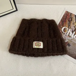Dettaglio della morbida maglia in mohair e toppa a cartone animato sul berretto
