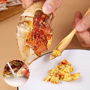 Golden 304 stainless steel crab spoon tool for eating crab on elegant white plate