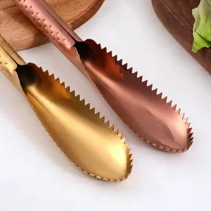 Dual-color gold and rose gold stainless steel fish scale scrapers in kitchen setting