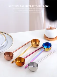 Detalle de cucharas de aceite de acero inoxidable 304 en oro, oro rosa y colores arcoíris
