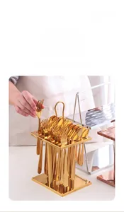 Detail of hand taking a golden fork from a luxury 36-piece stainless steel cutlery set rack