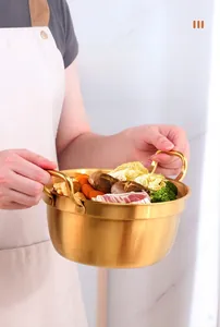 Close-up of golden stainless steel pot with hammered texture used for ramen and meat