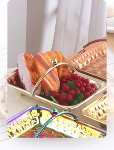 Detail van gehamerde roestvrijstalen trays met handgrepen in goud en roségoud kleur
