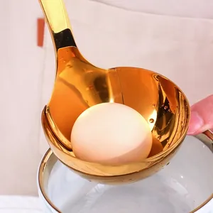 Golden 304 stainless steel oil separator ladle with long handle holding a single egg