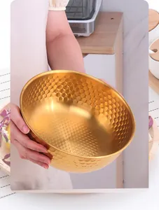 Close-up of golden stainless steel salad bowl with honeycomb texture in kitchen