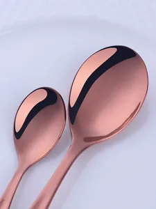 Detailed macro view of polished rose gold stainless steel spoons with a mirror finish