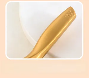 Close-up of golden stainless steel ergonomic handle with brushed metal anti-slip texture