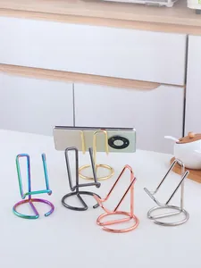 Macro detail of minimalist metal phone holders in five vibrant colors with round bases