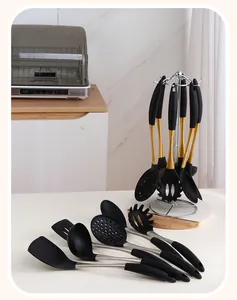 Close-up of 7-piece stainless steel kitchen tool set with black handles on rotating stand