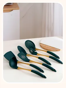 Macro detail of dark green silicone kitchen utensils with elegant gold metal handles