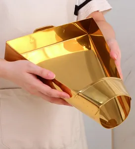 Close-up of golden stainless steel food scoop used for French fries and snacks