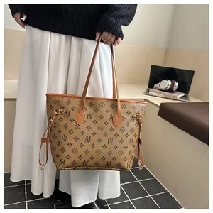 Macro shot of brown monogram tote bag with leather straps and side drawstrings