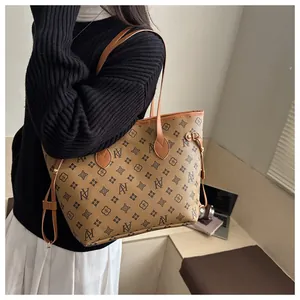 Close-up of vintage brown tote bag with classic monogram print and long shoulder strap
