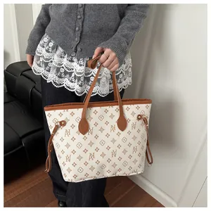 Detailed view of the AN monogram pattern and brown leather trim on the tote bag