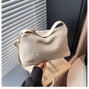 Close-up of soft cream faux shearling texture with leather strap and gold hardware