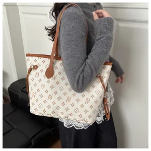 Detailed macro view of large tote bag with brown monogram pattern on creamy leather