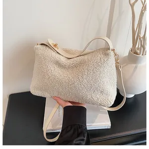 Close-up of plush shearling bag texture with golden twist lock and leather strap