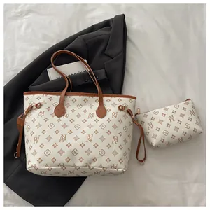 Close-up of cream tote bag with monogram print, drawstring detail and matching pouch