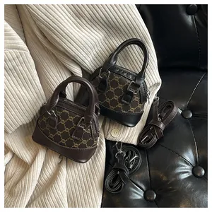 Detail view of mini monogram shell bags in brown and black on a knit sweater background