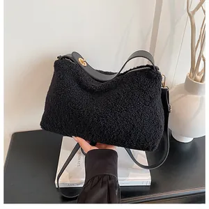 Detail of black plush faux lamb wool shoulder bag with leather strap and gold buckle