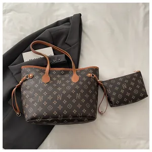 Detail shot of the brown monogram tote bag and matching zippered pouch on white background