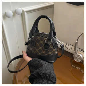 Detailed view of mini shell handbag with dark brown monogram and black leather handle
