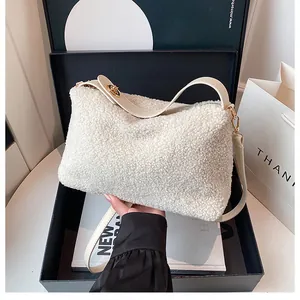 Detail of white teddy fabric handbag showing soft texture and gold metal hardware link