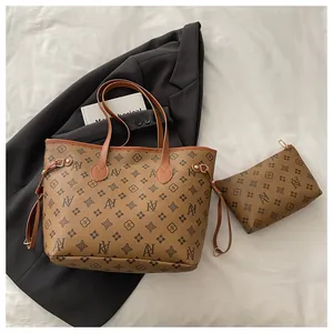 Detail view of the brown monogram tote bag set including a matching zipper pouch on white fabric