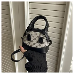 Detail of a mini shell bag featuring classic monogram canvas with black leather trim
