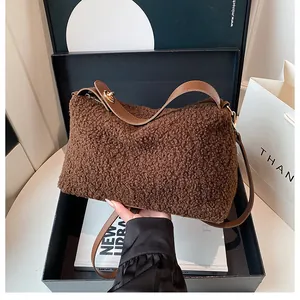 Detail of plush brown teddy bag with leather strap and gold buckle in a gift box