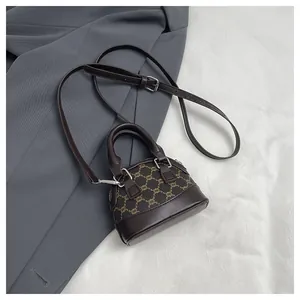Detailed top view of a mini shell bag with retro pattern and adjustable leather strap