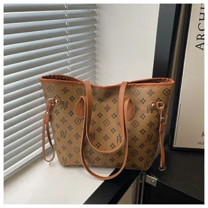 Detail view of the monogram printed tote bag with functional side drawstring and leather strap