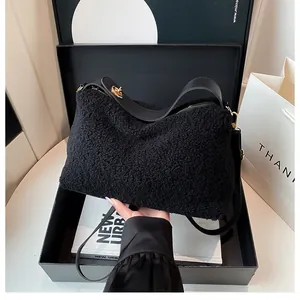 Close-up of black plush handbag texture with golden metal clasp and leather strap